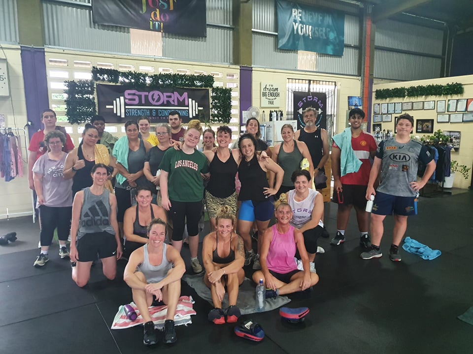 Large group photo of members on the gym floor after a workout